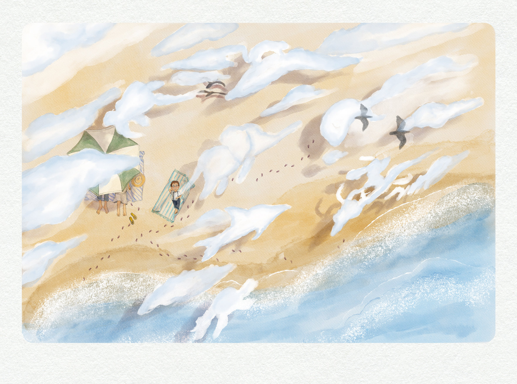 Seen from above, a boy lies on a towel on the beach while cloud shadows drift over the sand